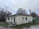 Back of a small beige home with an air conditioning unit, large windows, and door at 34 W Main St, Brownsburg, IN 46112