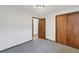 Cozy bedroom featuring gray carpeting and wooden closet doors for organized storage at 3509 River Bluff Rd, Anderson, IN 46012