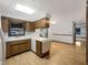 Bright kitchen with wood cabinets, laminate floors, and breakfast bar perfect for dining at 3509 River Bluff Rd, Anderson, IN 46012