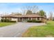 Charming brick ranch home featuring a spacious driveway, manicured landscaping, and a welcoming teal-colored front door at 3602 N County Road 950 E, Brownsburg, IN 46112