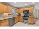 Modern kitchen with stainless steel appliances, granite counters, tile backsplash, and warm wood cabinets at 3602 N County Road 950 E, Brownsburg, IN 46112