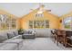 Bright living room featuring large windows, a ceiling fan, a sectional sofa, and a bar with stool seating at 3602 N County Road 950 E, Brownsburg, IN 46112