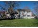 Exterior rear view of home featuring a large backyard with mature trees at 3705 River Rd, Columbus, IN 47203