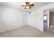 Bedroom features neutral carpeting, a ceiling fan, and a doorway with an attached bathroom at 3705 River Rd, Columbus, IN 47203