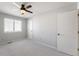 This is a standard bedroom with a ceiling fan, window, neutral carpet, and white doors at 3705 River Rd, Columbus, IN 47203