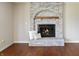 Close-up of brick fireplace with decorative arched trim and glass-doored firebox at 3705 River Rd, Columbus, IN 47203