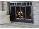 Close-up of brick fireplace with glass-doored firebox and decorative throw pillows at 3705 River Rd, Columbus, IN 47203