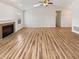 Spacious living room featuring a fireplace, vaulted ceiling, and bright, newly finished light hardwood floors at 3936 Par Dr, Indianapolis, IN 46268