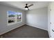 Carpeted bedroom includes neutral walls, ceiling fan, and a window overlooking the street at 3951 Narrowleaf Ct, Indianapolis, IN 46235