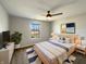 Comfortable bedroom with neutral tones, ceiling fan, and a view of the outdoors at 3951 Narrowleaf Ct, Indianapolis, IN 46235