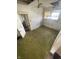 An empty bedroom needing repair, showcasing natural light from a window and dated carpet at 408 E Monroe St, Alexandria, IN 46001