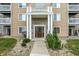 Apartment building entrance featuring a brown front door, brick facade, white columns and stone landscaping at 4925 Opal Ridge Ln # 309, Indianapolis, IN 46237