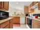 Well-lit kitchen features wooden cabinets, modern appliances, and views into the dining area at 4925 Opal Ridge Ln # 309, Indianapolis, IN 46237