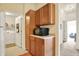 Bright kitchen featuring wooden cabinets, a microwave, and an adjacent laundry area at 4925 Opal Ridge Ln # 309, Indianapolis, IN 46237