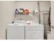 A functional laundry room with a washing machine, dryer, and overhead storage shelf at 4925 Opal Ridge Ln # 309, Indianapolis, IN 46237
