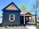 Charming home featuring dark siding, wooden accents, a covered porch, and a uniquely shaped window at 511 N Clark St, Lebanon, IN 46052