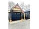 Detached garage featuring dark siding and wooden design elements, matching the main house at 511 N Clark St, Lebanon, IN 46052