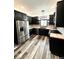 Stylish kitchen boasts black cabinets, stainless steel fridge, and ample counter space with modern lighting at 511 N Clark St, Lebanon, IN 46052