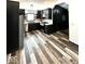 Modern kitchen featuring stainless steel appliances, dark cabinets, and stylish wood-look flooring throughout at 511 N Clark St, Lebanon, IN 46052