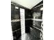 Updated stand-up shower with black tiles, recessed shelf, and glass block window accents at 511 N Clark St, Lebanon, IN 46052