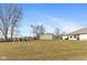Expansive backyard showcasing a play set, mature trees, and a large storage shed at 5529 W Mccord Rd, McCordsville, IN 46055
