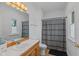 Bathroom with a oak vanity, a stylish framed mirror, and a shower with a patterned curtain at 5529 W Mccord Rd, McCordsville, IN 46055