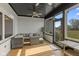 Relaxing sunroom featuring a brick accent wall, hardwood floors, and outdoor access at 5529 W Mccord Rd, McCordsville, IN 46055