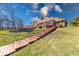 Lush backyard featuring a multi-tiered deck, brick retaining wall, and access steps at 563 E Greencastle Rd, Mooresville, IN 46158