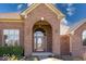 Close-up of the red brick front entrance with an arched entryway, decorative windows, and mature landscaping at 563 E Greencastle Rd, Mooresville, IN 46158
