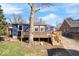 Backyard view showcasing the spacious deck, fenced yard, and mature tree shading the property at 5884 Kingsley Dr, Indianapolis, IN 46220