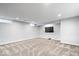 Finished basement offers neutral carpet, recessed lighting, and a large window at 5884 Kingsley Dr, Indianapolis, IN 46220