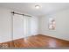 Bright bedroom featuring hardwood floors, light walls, and a modern sliding closet door at 5884 Kingsley Dr, Indianapolis, IN 46220