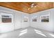 Bright living room featuring a unique wood plank ceiling, neutral furniture, and an abundance of natural light at 5884 Kingsley Dr, Indianapolis, IN 46220