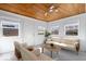 Bright living room featuring a unique wood plank ceiling, neutral furniture, and an abundance of natural light at 5884 Kingsley Dr, Indianapolis, IN 46220