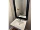 A quaint bathroom featuring a pedestal sink with a reflective mirror, enhancing the room's brightness at 614 E 11Th St, Indianapolis, IN 46202