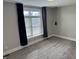 Bedroom with a large window covered by gray curtains and new carpet flooring at 614 E 11Th St, Indianapolis, IN 46202