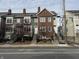 Three, two-story brick and painted-wood townhomes are featured in this exterior view at 614 E 11Th St, Indianapolis, IN 46202