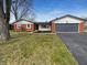 Charming single-story home boasts a well-manicured lawn, brick accents and an attached two car garage at 6512 Buttonwood Dr, Noblesville, IN 46062