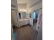 Bathroom with a double vanity, a mirror, and vinyl floors with easy access to bedroom and closet at 6812 Cadwell Cir, Indianapolis, IN 46237