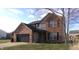 View of a two-story home with a brick and vinyl facade, a two-car garage, and a well-manicured lawn at 6812 Cadwell Cir, Indianapolis, IN 46237