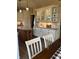 An eat-in kitchen features white cabinets, updated lighting, island and hardwood flooring at 6812 Cadwell Cir, Indianapolis, IN 46237