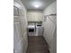 The laundry room features updated flooring, with a full washer and dryer set and shelving above at 6812 Cadwell Cir, Indianapolis, IN 46237