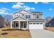 Charming two-story home featuring a covered porch, a two-car garage, and a well-lit exterior at 7152 Jackson Dr, Cumberland, IN 46229