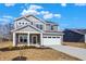 Charming two-story home featuring a covered porch, a two-car garage, and a well-lit exterior at 7152 Jackson Dr, Cumberland, IN 46229