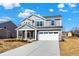 Charming two-story home featuring a covered porch, a two-car garage, and a well-lit exterior at 7152 Jackson Dr, Cumberland, IN 46229