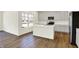 Bright kitchen boasts white cabinets, stainless appliances, and hardwood floors at 7152 Jackson Dr, Cumberland, IN 46229