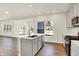 Bright kitchen featuring an island with a sink, stainless steel appliances, and a view of the backyard at 7152 Jackson Dr, Cumberland, IN 46229