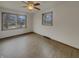 Bedroom featuring neutral walls, wood-look flooring, ceiling fan and a window view of the quiet, tree-lined street at 8507 Palm Ct, Indianapolis, IN 46219