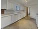 Functional kitchen featuring white cabinetry, essential appliances, and a sink with a window, bathed in natural light at 8507 Palm Ct, Indianapolis, IN 46219