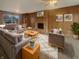 Cozy living room showcasing wood paneling, a brick fireplace, plush seating, and a stylish rug at 8507 Palm Ct, Indianapolis, IN 46219